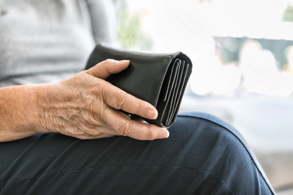 elderly woman holds purse
